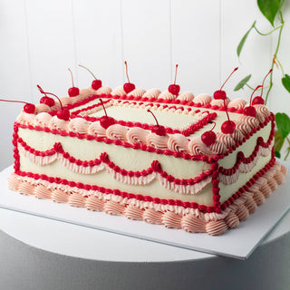 vintage large sheet cake, in red, pink, and white, with cherries on top